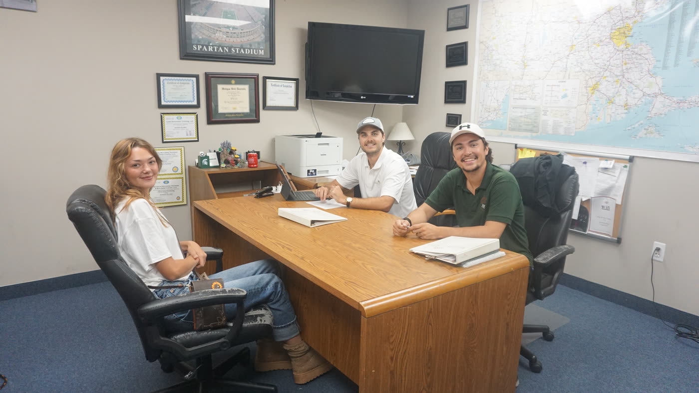 Acorn Pro Painting team members meeting around a desk at the office